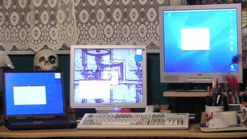 [Three computers, three screens, one keyboard and one mouse]