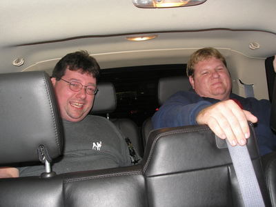 [Joe and Kurt crammed into the back of a sport utility vehicle]