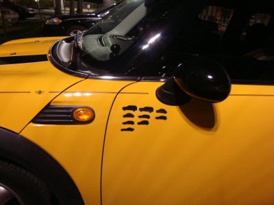 [A Mini Cooper with the silhouette of nine vehicles on the side]